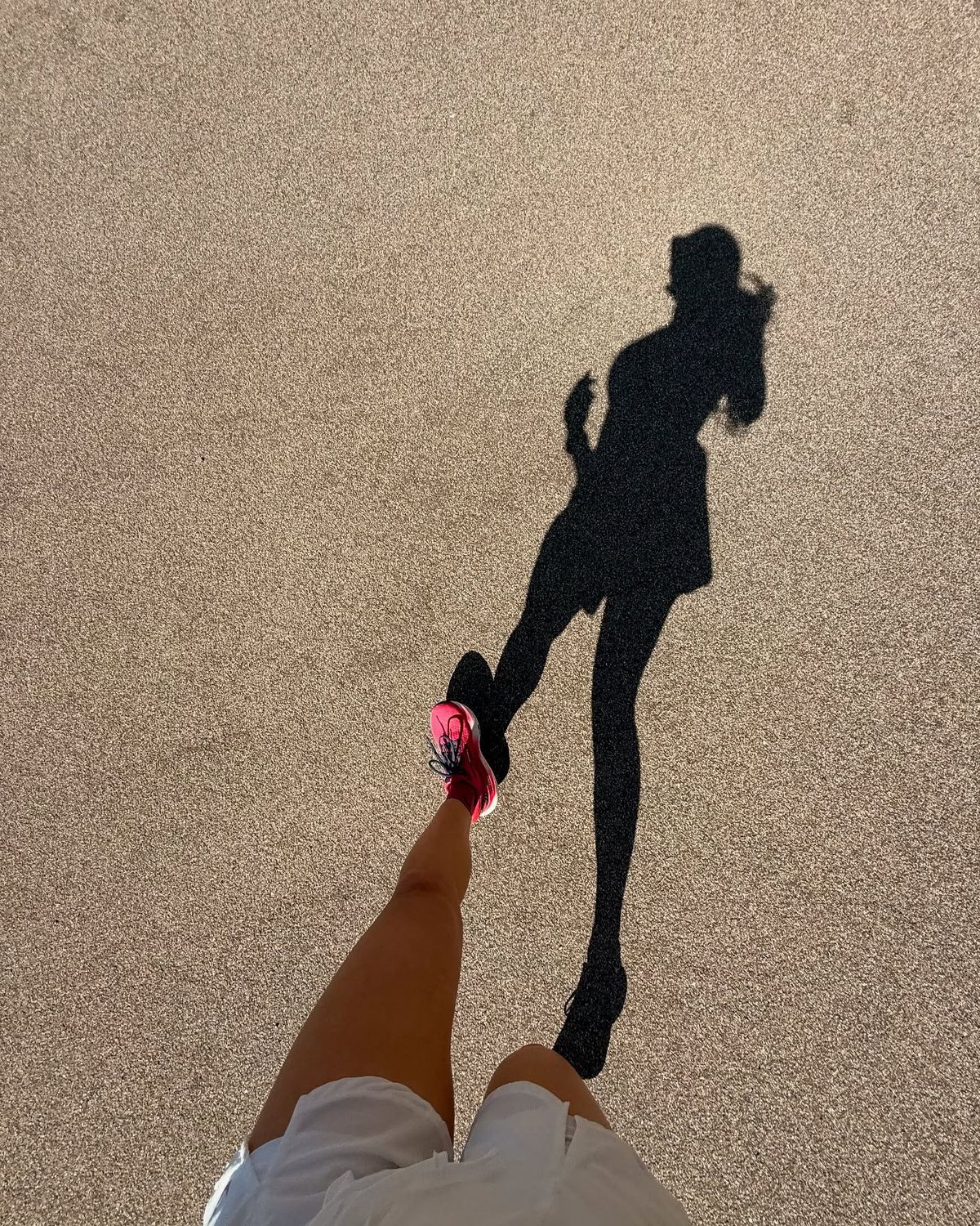Persona corriendo, sombra sobre el asfalto